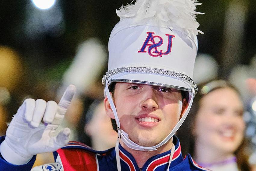 Jaguar Marching Band guy smiling and holding his J's up