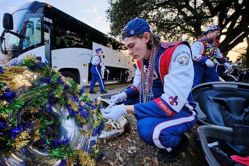 Jag Marching Band decorating his instrument with Mardi Gras decoration