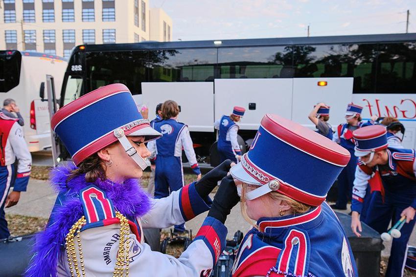 Jaguar Marching Band member fixing her teammate's hat