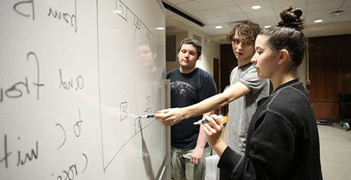 Students working at the white board,