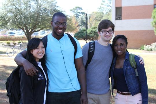 Two guys and two girls with arms around each other